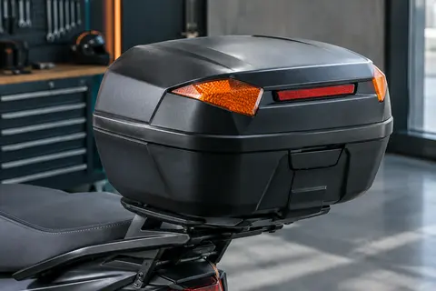 Top-case moto Sevico X12 noir en plastique, avec éléments réfléchissants, présenté sur un support arrière.