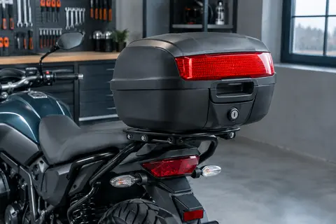 Top-case rigide noir mat avec réflecteur arrière, monté sur le porte-bagages d’une moto